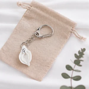 Schlüsselanhänger in Vulvaform mit Klitorisperle